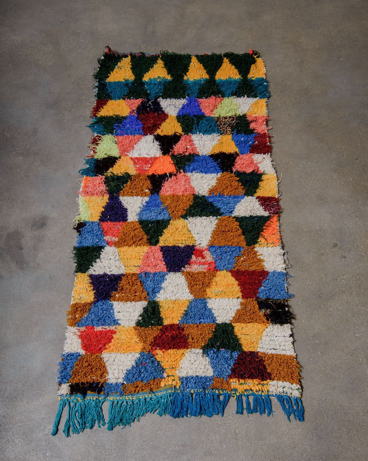 Multicoloured geometric patterned rug on a gray surface